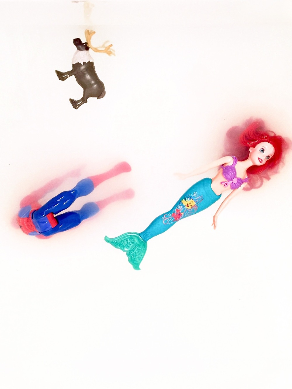 Toys in a bathtub featuring Mermaid Doll, Spider-Man and a moose.